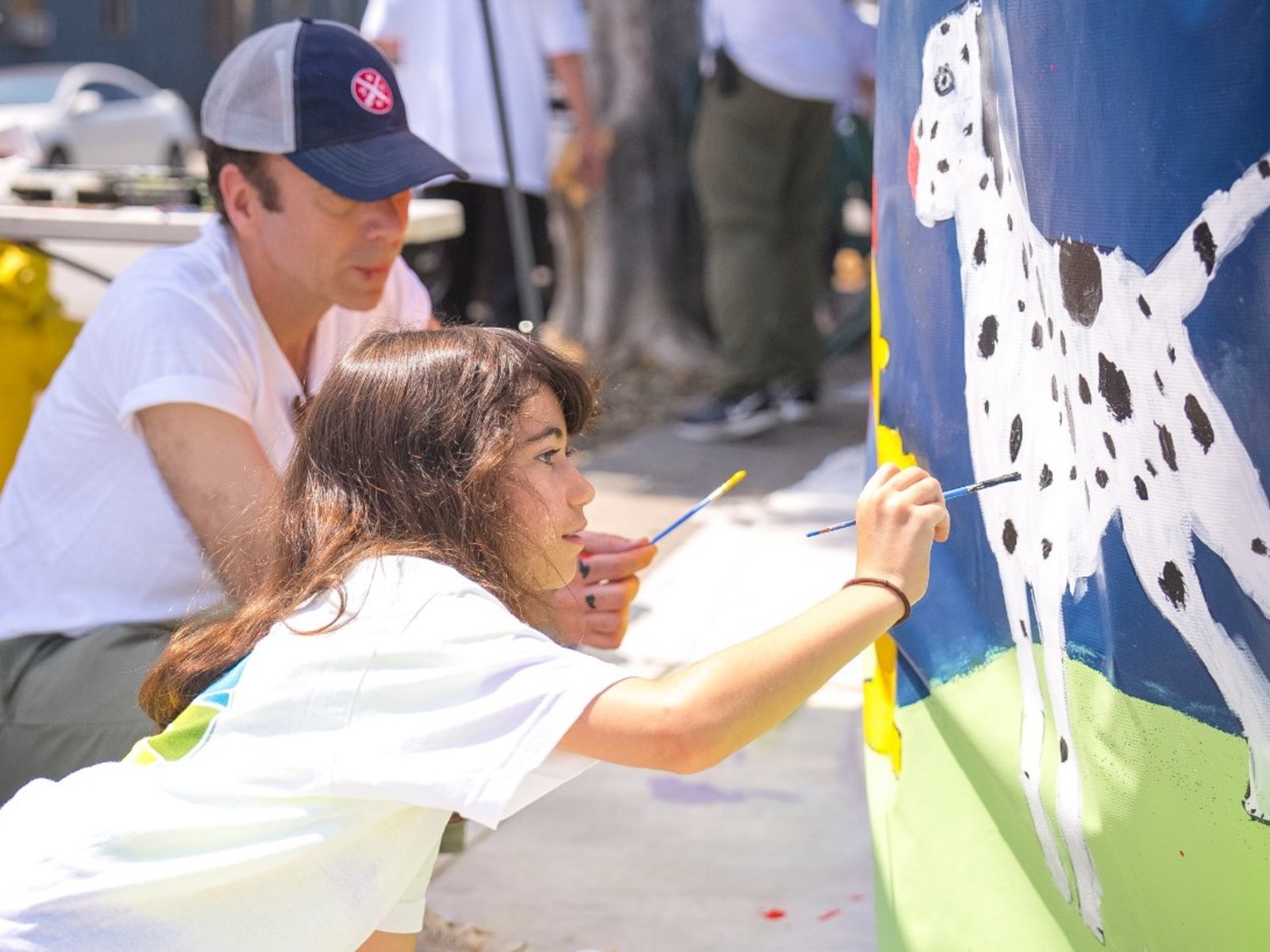 Mladý dobrovolník přidává skvrny k dalmatinovi