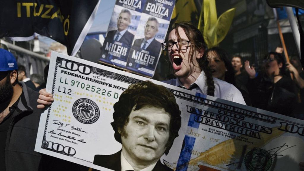 TIAGO CODEVILLA DRŽÍ OBŘÍ 100DOLAROVOU BANKOVKU S TVÁŘÍ ARGENTINSKÉHO KONGRESMANA A PREZIDENTSKÉHO KANDIDÁTA ZA ALIANCI LA LIBERTAD AVANZA BĚHEM PŘEDVOLEBNÍHO SHROMÁŽDĚNÍ V SAN MARTÍN V PROVINCII BUENOS AIRES